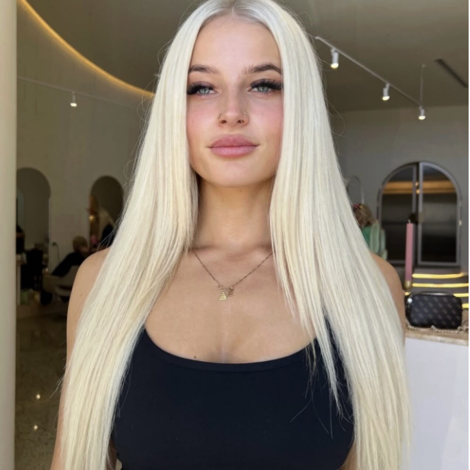 Wavy long blonde hair styled to the side, featuring the Platinum Blonde Service by blonde hairdresser in Melbourne.