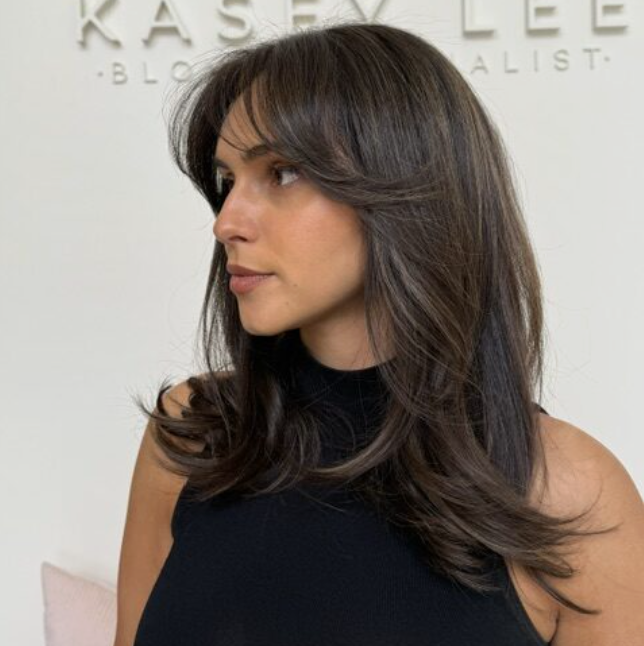 Wavy long blonde hair styled to the side, featuring the Platinum Blonde Service by blonde hairdresser in Melbourne.